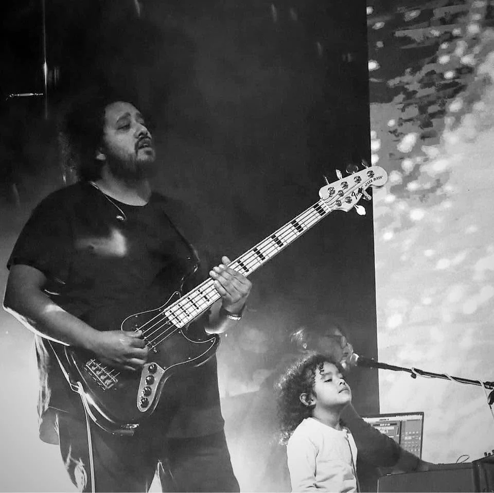 Adrian Jonathan playing bass during a worship performance