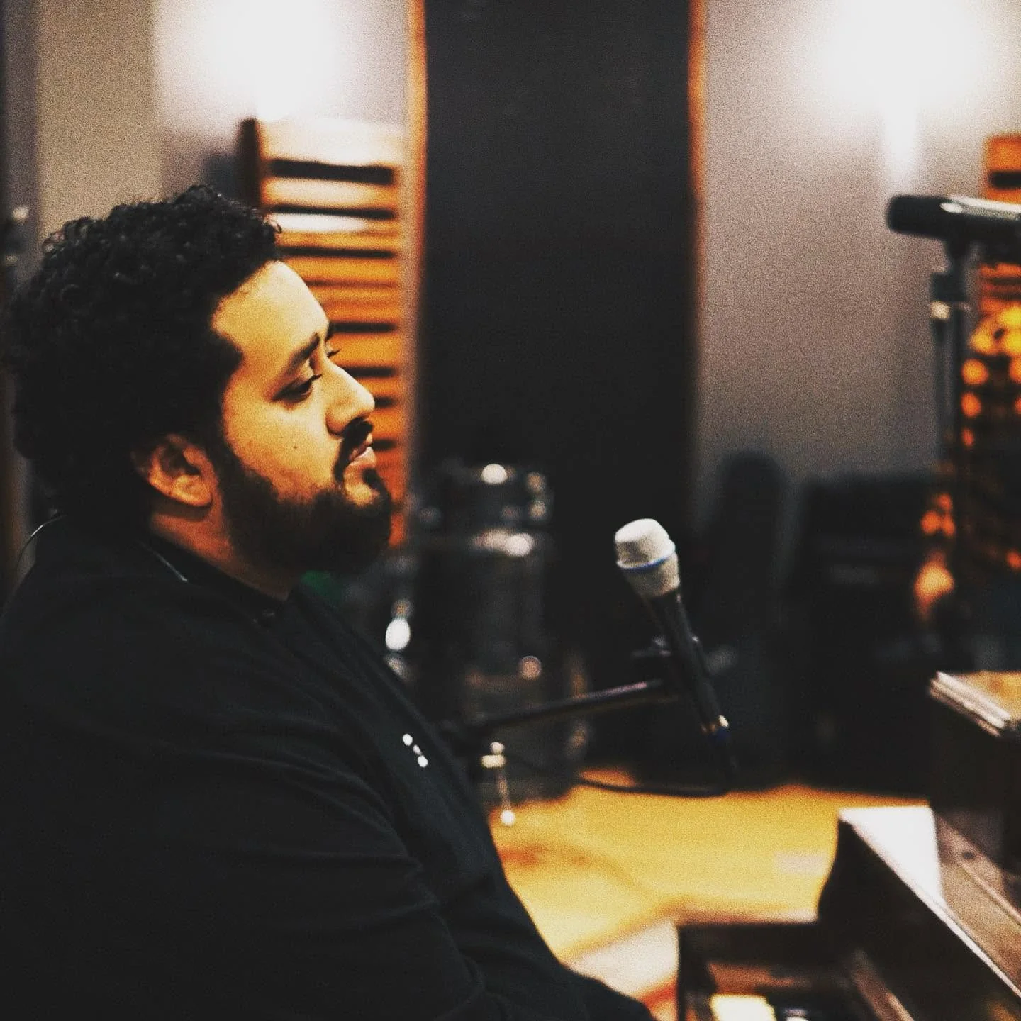 Adrian Jonathan recording in the studio at the microphone